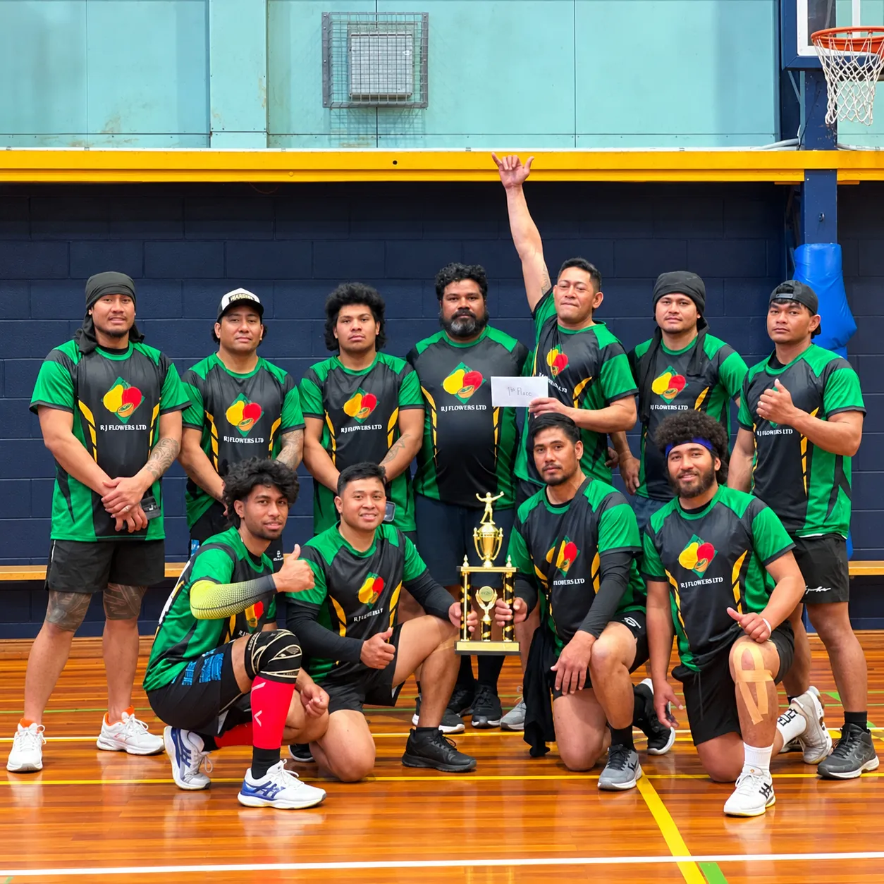 The RJ Flowers team in their branded team shirts, celebrating a first-place trophy.